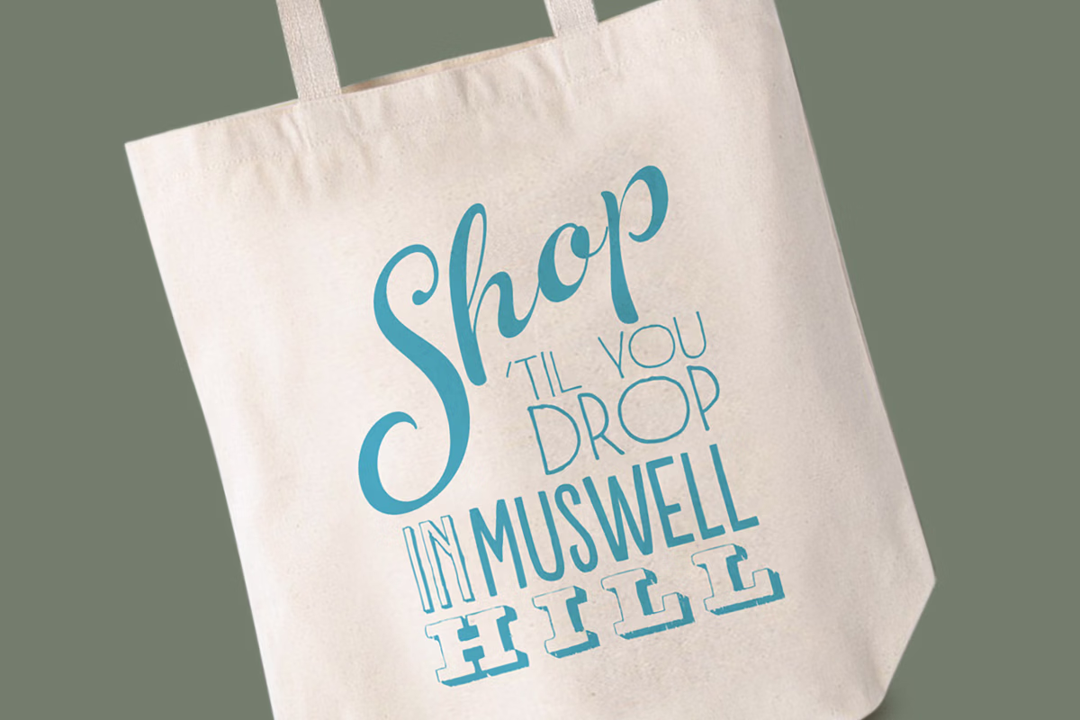A beige tote bag with blue text that reads 
