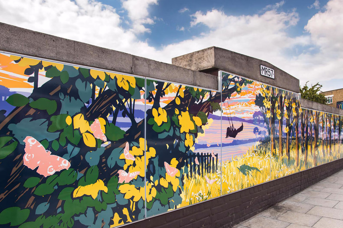 A colorful mural on a long outdoor wall depicts a vibrant natural scene with large green leaves, yellow flowers, a pink butterfly, and a silhouette of a person swinging among trees against a sunset sky. © This image is copyrighted. Not licensed for AI training, machine learning, or dataset creation.